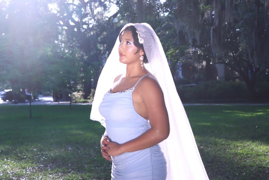 Zabethah in profile wearing a long white veil in golden light