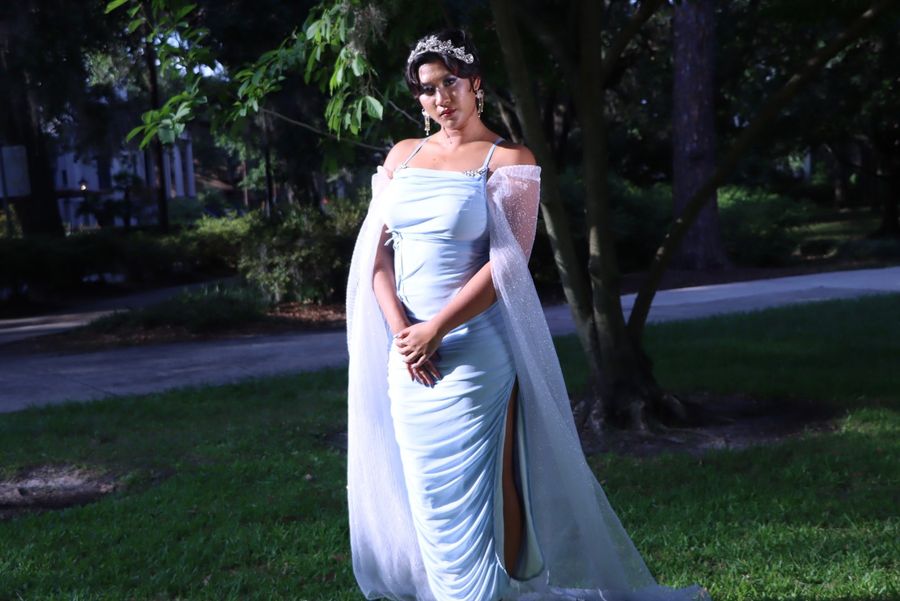 Zabethah standing in an ice-blue gown with a sheer cape