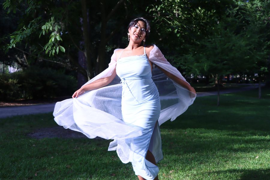 Ice-blue gown mid-twirl in a garden