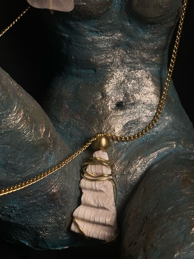 White tassel pendant on a sculpted bust